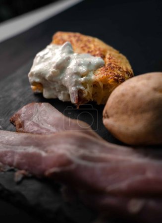Delight in the harmonious fusion of Spanish and Italian flavors with our exquisite potato omelet drizzled with creamy carbonara sauce. Presented on a pristine white plate, surrounded by the fresh ingredients that make it unforgettable: potatoes, eggs