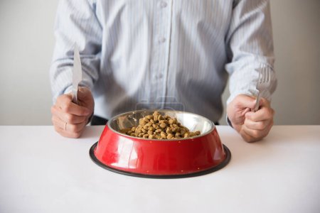 Téléchargez les photos : Hombre comiendo comida para perros 5 - en image libre de droit