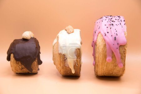 Téléchargez les photos : Three handmade New York roll with white, pink and black icing - en image libre de droit