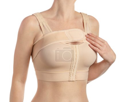Téléchargez les photos : Jeune femme portant un soutien-gorge de compression avec un stipe après l'augmentation mammaire. Isolé sur fond blanc avec chemin de coupe. - en image libre de droit