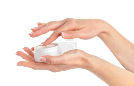Frasco de crema cosmética de mano femenina sobre fondo blanco.