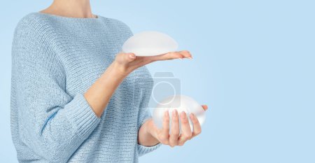 Téléchargez les photos : Femme tenant et serrant des implants ronds. Espace de copie - en image libre de droit