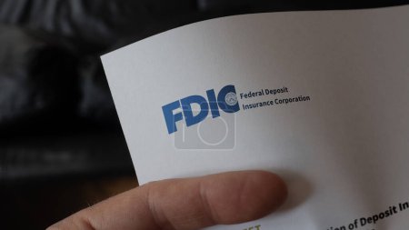 Photo for May 18th 2023. Someone holding a letter addressed by the Federal Deposit Insurance Corporation. The FDIC logo on a letterhead. - Royalty Free Image