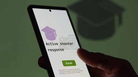 28th August 2023. A student holds a phone, enrolls in courses to study active shooter response program, learn new skill and pass certification. Text in English, English text.