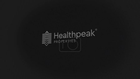 Foto de 07 Septiembre 2023 Long Beach, California. El logotipo de Healthpeak en una pared blanca de pantallas. Marca Healthpeak en un dispositivo. - Imagen libre de derechos