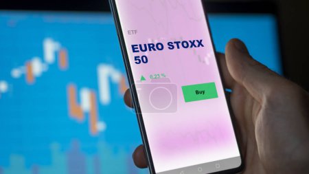 Téléchargez les photos : Un investisseur analysant le fonds euro stoxx 50 etf sur un écran. Un téléphone affiche les prix de EURO STOXX 50 - en image libre de droit