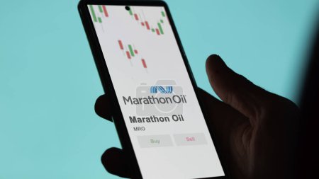 Téléchargez les photos : Le logo de Marathon Oil sur l'écran d'un échange. Marathon Stocks de pétrole, $MRO sur un appareil. - en image libre de droit