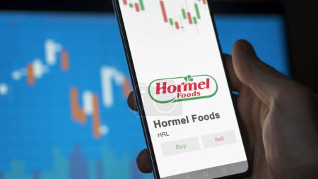 Foto de El logotipo de Hormel Foods en la pantalla de un intercambio. Acciones de precios de Hormel Foods, $HRL en un dispositivo. - Imagen libre de derechos