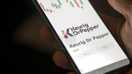 Foto de El logo de Keurig Dr Pepper en la pantalla de un intercambio. Keurig Dr acciones de precios de pimienta, $KDP en un dispositivo. - Imagen libre de derechos