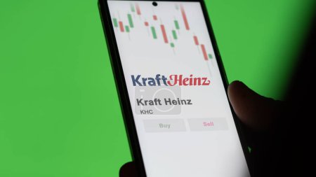 Foto de El logotipo de Kraft Heinz en la pantalla de un intercambio. acciones de precios de Kraft Heinz, $KHC en un dispositivo. - Imagen libre de derechos