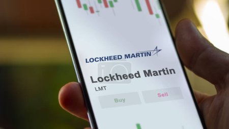 Foto de El logotipo de Lockheed Martin en la pantalla de un intercambio. Lockheed Martin acciones de precios, $LMT en un dispositivo. - Imagen libre de derechos