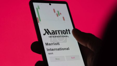 Téléchargez les photos : Le logo de Marriott International sur l'écran d'un échange. Marriott International actions de prix, $MAR sur un appareil. - en image libre de droit