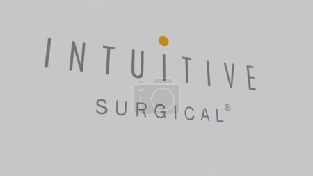 Foto de El logotipo de Intuitive Surgical en una pared blanca de pantallas. Marca quirúrgica intuitiva en un dispositivo. - Imagen libre de derechos