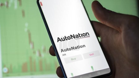 Foto de El logotipo de AutoNation en la pantalla de un intercambio. Acciones de precio de nación automática, $ANon un dispositivo. - Imagen libre de derechos