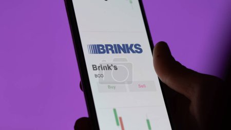 Photo for The logo of Brinks on the screen of an exchange. Brinks technology price stocks, $BCO on a device. - Royalty Free Image