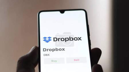 Téléchargez les photos : La page de trading de Dropbox en bourse, un actionnaire analysant $DBX, Dropbox, sur un appareil. - en image libre de droit