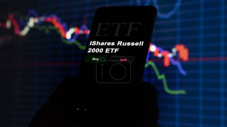 Téléchargez les photos : 17 novembre 2023. Un investisseur analyse par téléphone un fonds etf iShares Russell 2000 ETF. - en image libre de droit