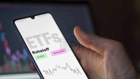 Photo for December 2022. An investor analyzes the raw material ETF fund on phone screen Rohstoff-ETFs. German text translated: Kaufen, Verkaufen, Rohstoff buy, sell, raw material - Royalty Free Image