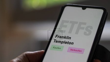Photo for December 2022. An investor analyzes the Franklin Templeton ETF fund on phone screen Franklin Templeton. German text translated: Kaufen, Verkaufen : buy, Sell - Royalty Free Image