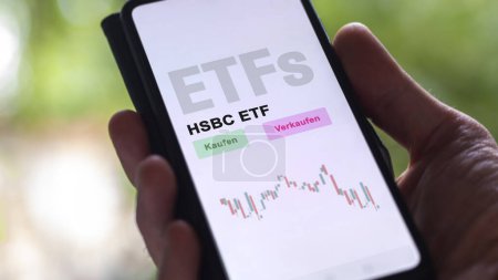Photo for December 2022. An investor analyzes the HSBC ETF ETF fund on phone screen HSBC ETF. German text translated: Kaufen, Verkaufen : buy, Sell - Royalty Free Image