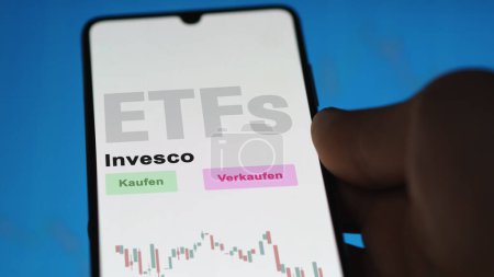Photo for December 2022. An investor analyzes the Invesco ETF fund on phone screen Invesco. German text translated: Kaufen, Verkaufen : buy, Sell - Royalty Free Image