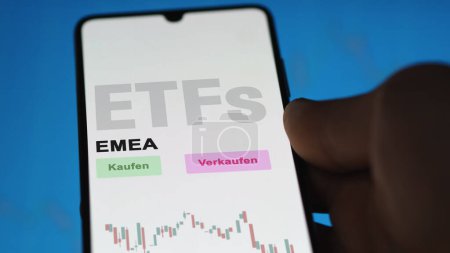 Photo for December 2022. An investor analyzes the EMEA ETF fund on phone screen EMEA-ETFs. German text translated: Kaufen, Verkaufen : buy, Sell - Royalty Free Image