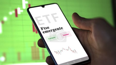 Téléchargez les photos : Un investisseur analysant un fonds etf. Texte de l'ETF en espagnol : FTSE emerging, buy, sell. - en image libre de droit