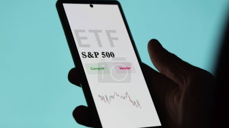 Foto de Un inversor analizando un fondo etf. Texto ETF en español: SandP 500, comprar, vender. - Imagen libre de derechos