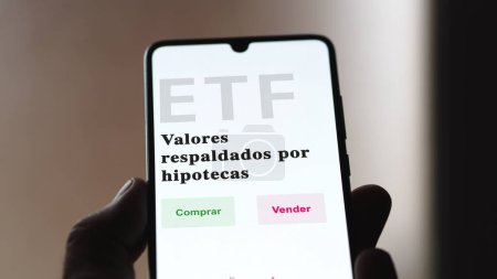 Photo for An investor analyzing an etf fund. ETF text in Spanish : mortgage backed securities, buy, sell. - Royalty Free Image