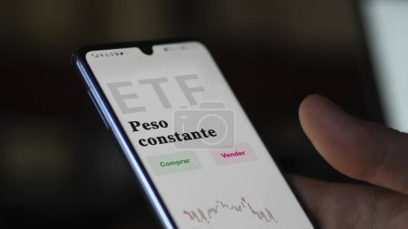 Téléchargez les photos : Un investisseur analysant un fonds etf. ETF texte en espagnol : constant weight, buy, sell. - en image libre de droit