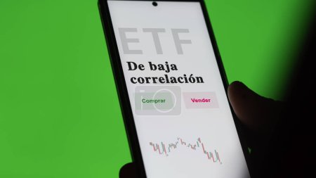 Photo for An investor analyzing an etf fund. ETF text in Spanish : low-correlation, buy, sell. - Royalty Free Image