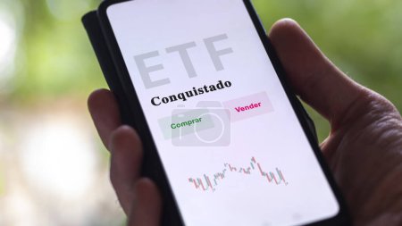 Photo for An investor analyzing an etf fund. ETF text in Spanish : currency-hedged, buy, sell. - Royalty Free Image