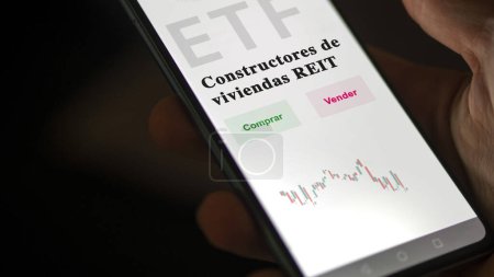 Téléchargez les photos : Un investisseur analysant un fonds etf. Texte de l'ETF en espagnol : homebuilders REIT, buy, sell. - en image libre de droit
