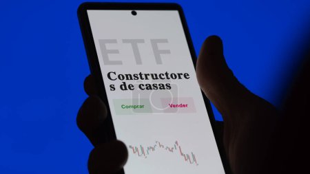 Foto de Un inversor analizando un fondo etf. Texto ETF en español: constructores de viviendas, comprar, vender. - Imagen libre de derechos