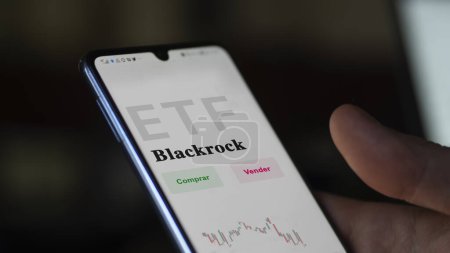 Téléchargez les photos : Mars 2023, Un investisseur analyse un fonds etf. Texte de l'ETF en espagnol : Blackrock, acheter et vendre. - en image libre de droit