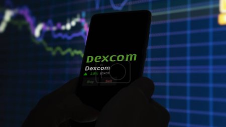 Foto de 15 de enero de 2024. El logotipo de Dexcom en la pantalla de un intercambio. Acciones de precio de Dexcom, $DXCM en un dispositivo. - Imagen libre de derechos