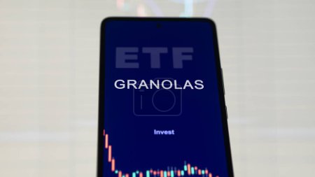 Foto de Acrónimo GRANOLAS en una aplicación telefónica, el inversor analiza el precio de una ETF granolas en una bolsa de valores. G.R.A.N.O.L.A.S. fondo en un teléfono inteligente. - Imagen libre de derechos