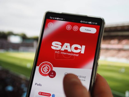 Foto de Un fan de Porto Alegre mira el SACI simbólico de su equipo en la aplicación Socios, el tope de mercado de $SACI de la nft en una pantalla. - Imagen libre de derechos