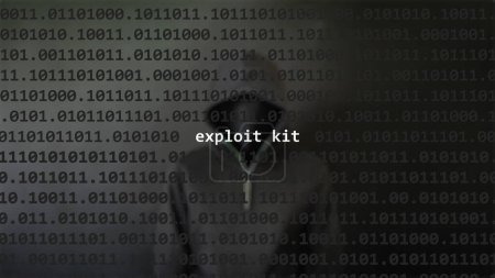 Cyber ataque explotar texto kit en pantalla de primer plano, hacker anónimo oculto con sudadera con capucha en el fondo borroso. Texto de vulnerabilidad en código binario del sistema en el programa editor.