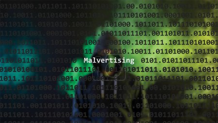 Cyber-Angriff Malvertising Text im Vordergrund, anonyme Hacker mit Kapuzenpulli im verschwommenen Hintergrund versteckt. Verwundbarkeitstext im binären Systemcode im Editor-Programm.