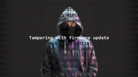 Cyber attack tampering with firmware update text in foreground screen, anonymous hacker hidden with hoodie in the blurred background. Vulnerability text in binary system code on editor program.