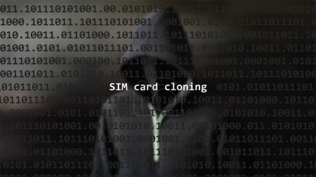 Photo for Cyber attack sim card cloning text in foreground screen, anonymous hacker hidden with hoodie in the blurred background. Vulnerability text in binary system code on editor program. - Royalty Free Image