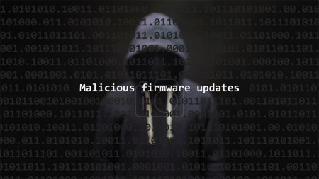 Cyber attack malicious firmware updates text in foreground screen, anonymous hacker hidden with hoodie in the blurred background. Vulnerability text in binary system code on editor program.