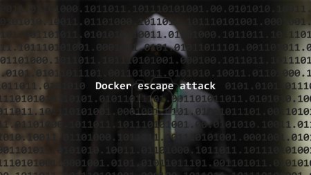 Cyber attack docker escape attack text in foreground screen, anonymous hacker hidden with hoodie in the blurred background. Vulnerability text in binary system code on editor program.