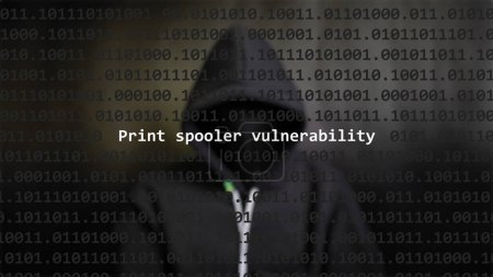 Cyber attack print spooler vulnerability text in foreground screen, anonymous hacker hidden with hoodie in the blurred background. Vulnerability text in binary system code on editor program.