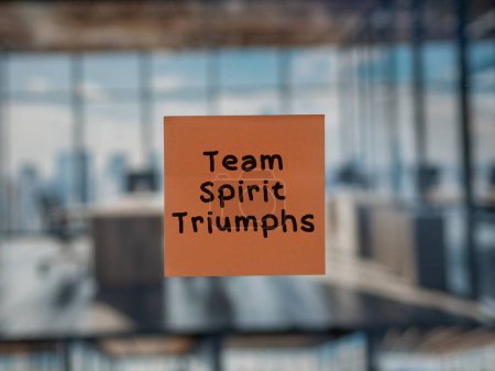 Post note on glass with 'Team Spirit Triumphs'.