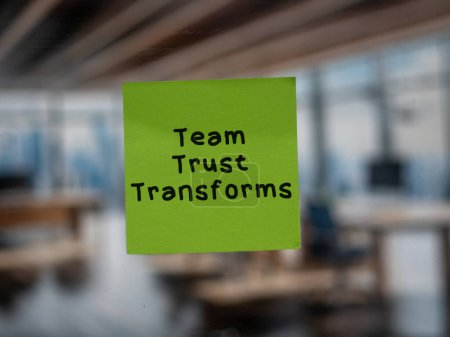 Post note on glass with 'Team Trust Transforms'.