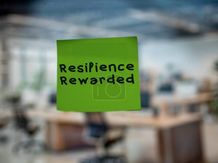 Post note on glass with 'Resilience Rewarded'.