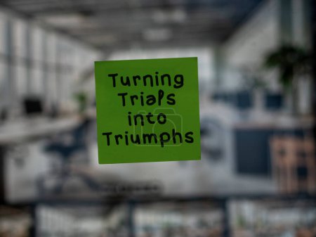 Post note on glass with 'Turning Trials into Triumphs'.