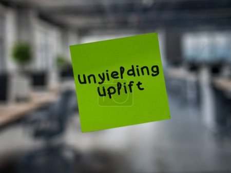 Post note on glass with 'Unyielding Uplift'.